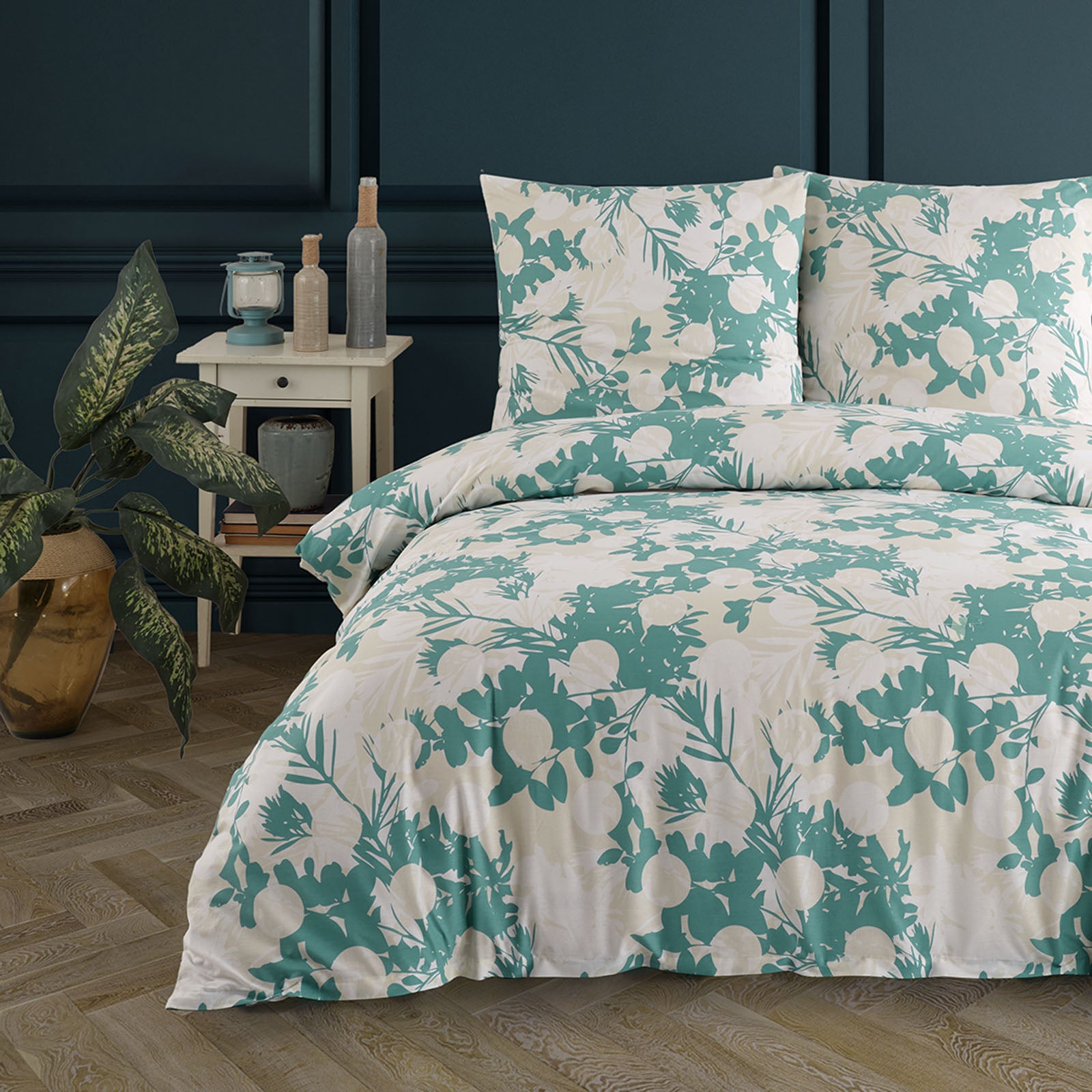 Doppelbett mit weißer Bettwäsche, verziert mit grünem, botanischem Muster aus Blättern und Früchten, dekoriert in einem stilvollen Schlafzimmer mit Pflanzen und Nachttisch.